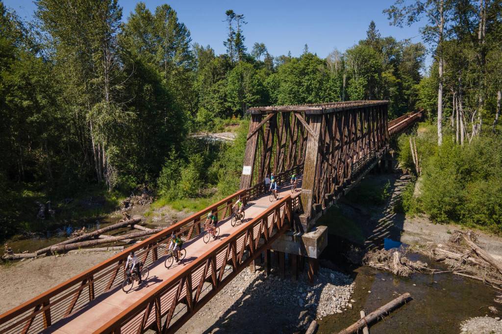 Photo by Jesse Major/Rails-to-Trails Conservancy
Washington state Gov. Jay Inslee, third from left, and his team ride across the bridge at Railroad Bridge Park on the Olympic Discovery Trail on June 7.
