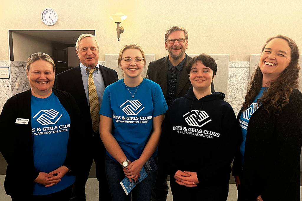 Photo courtesy Mary Budke/ Pearle Peterson, center, and other Boys & Girls Clubs representatives stand with state representatives Steve Tharinger and Mike Chapman while advocating for the clubs and other issues impacting youth. Chapman, a former board member of the Olympic Peninsula clubs, asked Peterson to sing and she did so in the middle of the Columbia Room.