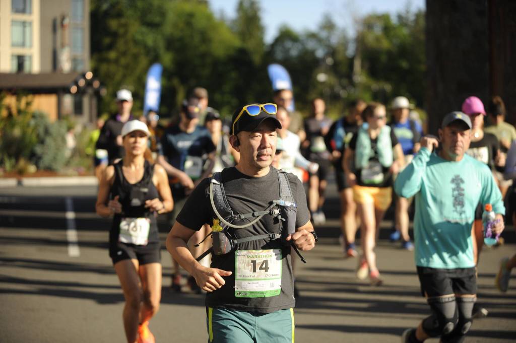 Sequim Gazette photo by Michael Dashiell / Van Onishi, of Seattle, and other runners break from the starting line of the full North Olympic Discovery Marathon in Blyn on June 4.