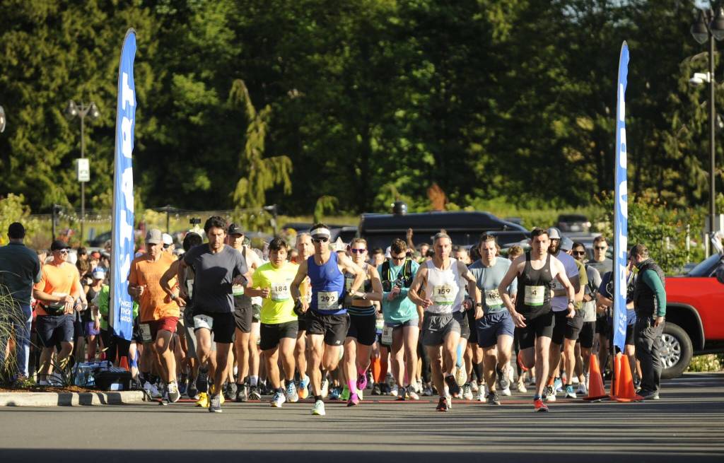 Sequim Gazette photo by Michael Dashiell / Runners break from the starting line of the full North Olympic Discovery Marathon in Blyn on June 4.