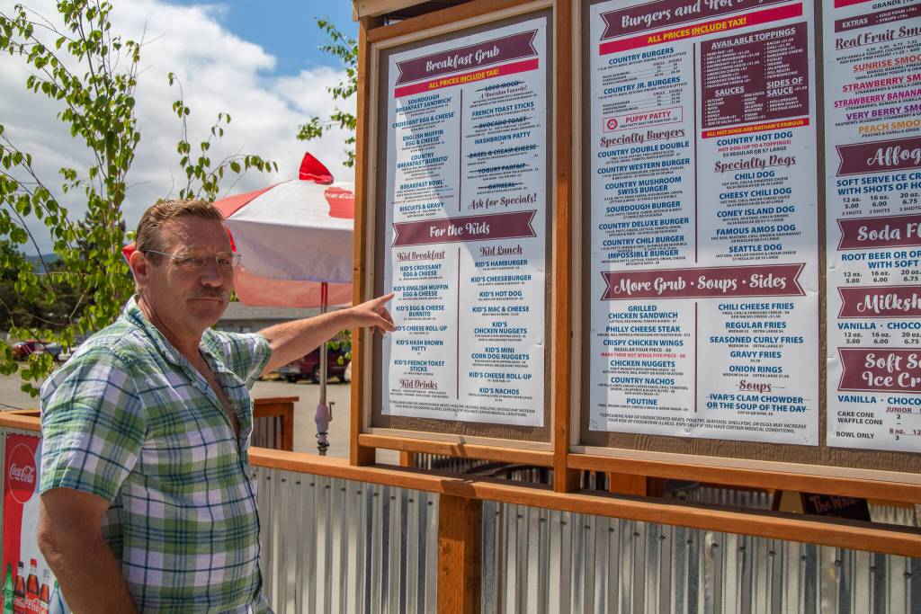 Sequim Gazette photo by Emily Matthiessen
Tracy Bloom points to the kids menu, emphasizing that the prices are so families can afford to eat at Country Coffee and Grub in Carlsborg for breakfast, lunch or dinner. He consulted clients of the local childcare center, Country Acre Child Care and Early Learning Center when choosing foods that children would enjoy.