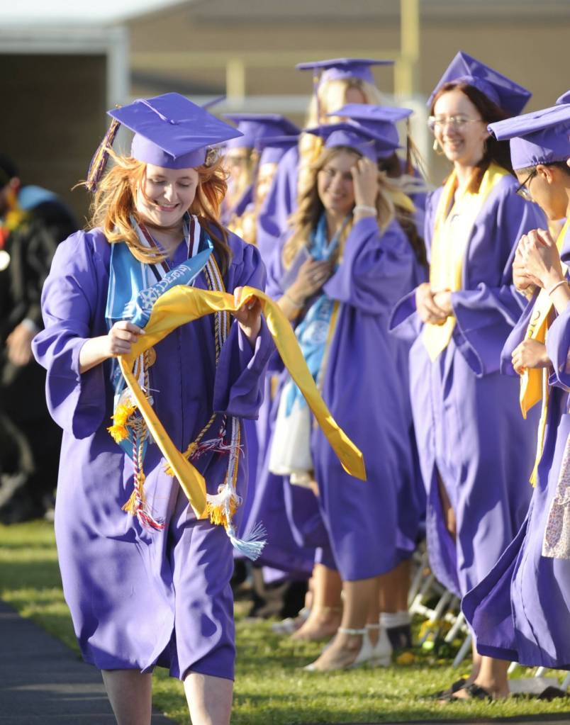 Sequim Gazette photo by Michael Dashiell / Ruby Coulson gathers her graduation sash and regalia as, despite some windy conditions, she and more than 160 classmates accepted diplomas at Sequim High Schools commencement ceremony on June 16.
