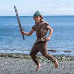 Sequim Gazette photo by Emily Matthiessen / Peter Pan, played by Rivers Maynard, flies across the Port Williams beach with his longsword drawn for a possible pirate confrontation. Maynard is one of 39 performers in Sequim Acrobatics upcoming production, Neverland, which can be experienced on Friday or Saturday of this week at Sequim High School Auditorium.