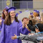 Sequim Gazette photo by Michael Dashiell / Anatasia Updike and fellow Sequim High grads-to-be accept high-fives from Sequim students and staff on the Sequim School District track on June 16.