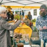 Photo by Andrew Wiese / Rose Harris shops with Jason Maloney of Duckabush Mushrooms at the Port Townsend Farmers Market in 2022.