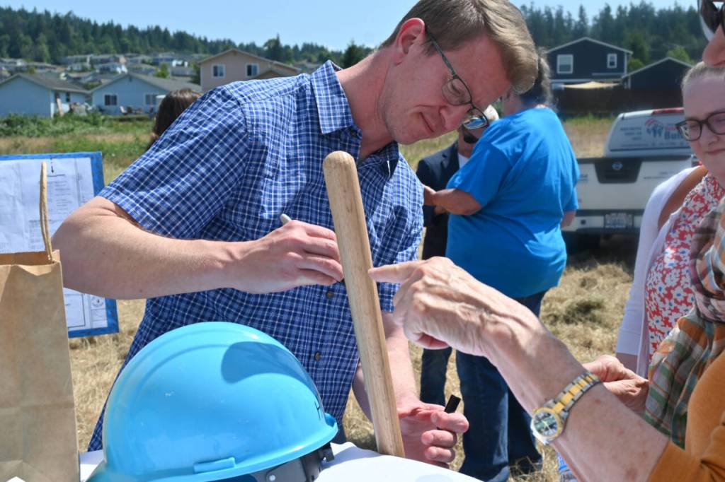 Sequim Gazette photo by Michael Dashiell / Congressman Derek Kilmer signs a shovel used in the groundbreaking of the Brownfield Road Project on July 5.