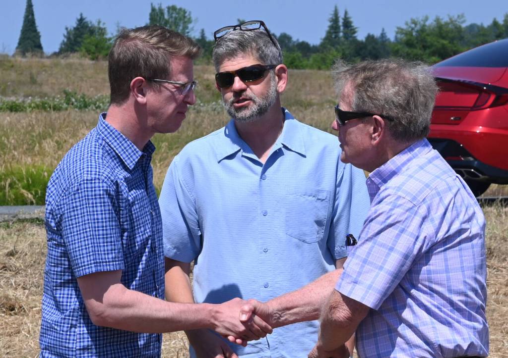 Sequim Gazette photo by Michael Dashiell / From left, U.S. Rep. Derek Kilmer talks with Clallam County commissioners Mark Ozias and Randy Johnson at a groundbreaking of the Brownfield Road Project in Sequim on July 5.