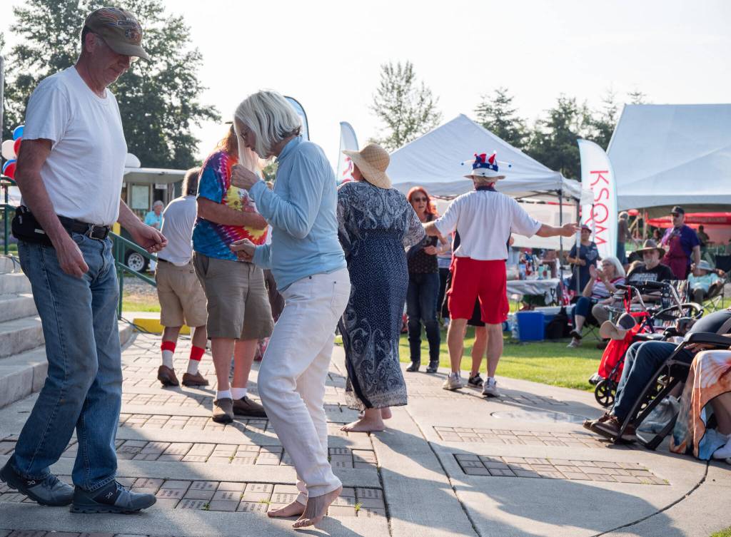 Sequim Gazette photo by Emily Matthiessen / The Buck Ellard Band draws dancers from the crowd during the Independence Day celebration.