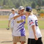 Sequim Greywolves Joel Hecht, center, bumps fists with a Victoria Raiders player after their clubs first friendly softball match-up on July 8 at Carrie Blake Community Park. Behind Hecht is teammate David Pugsley.