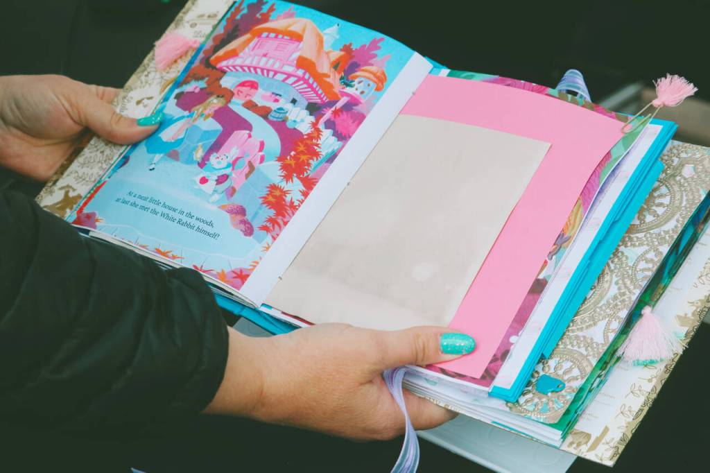 Photo courtesy of Sequim Farmers & Artisans Market / A closer look at a beautiful Alice in Wonderland-themed scrapbook by Frippery by Rose Rose Crawford . This was repurposed from a childrens book.