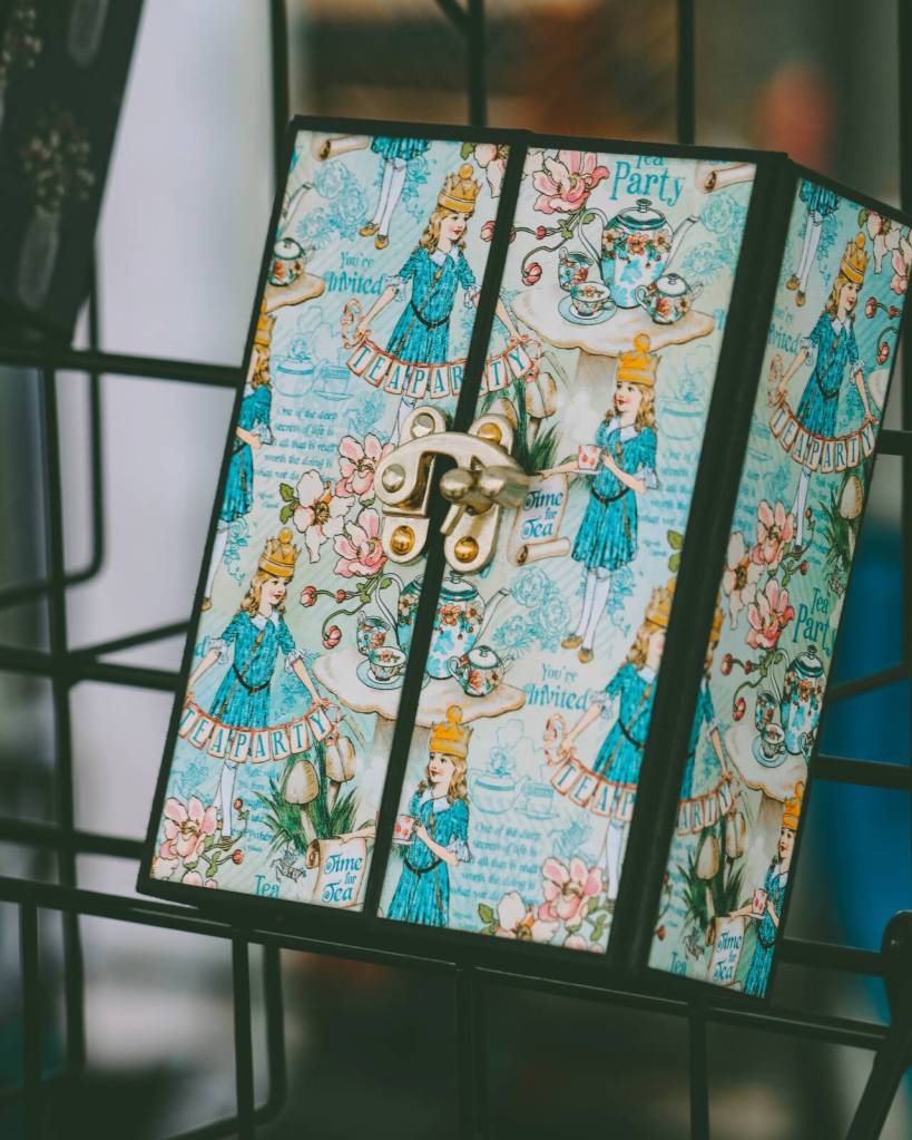 Photo courtesy of Sequim Farmers & Artisans Market / A close-up of a custom crafted Alice in Wonderland-themed notebook. The notebooks, made from paper and chipboard, each take about four hours to craft. The latch is fastened with brads.
