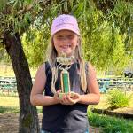 Kinlee Morris displays the trophy she earned as the first Helping Hands award at the Horse Show and Fair Qualifier in early July. Morris received the award for being helpful to other riders.