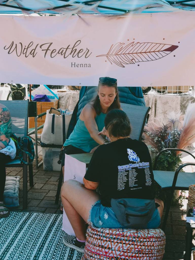 Photo courtesy of Sequim Farmers & Artisans Market/SFAM / Patience Edwards prepares to apply a henna tattoo to a customer at the Wild Feather Henna booth. Henna tattoos take about 20-25 minutes to dry.