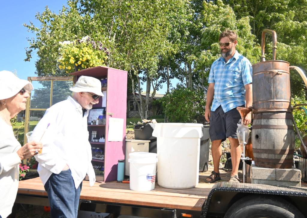 Sequim Gazette photo by Michael Dashiell
Jake Reichner, right, explains his lavender distillation process to visitors from Edmonds at Purple Path Lavender on July 23.