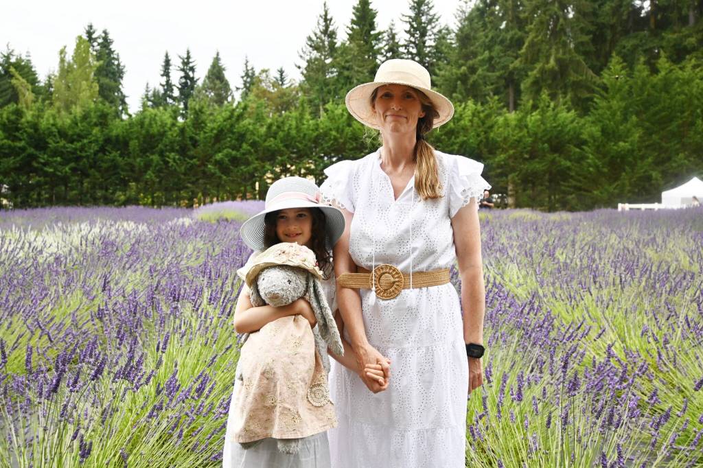 Sequim Gazette photo by Michael Dashiell / Elaine McSherry-Bisla, right and Aoise, holding Bebe, enjoy a sunny afternoon at Fleurish Lavender of Lost Mountain on July 22.