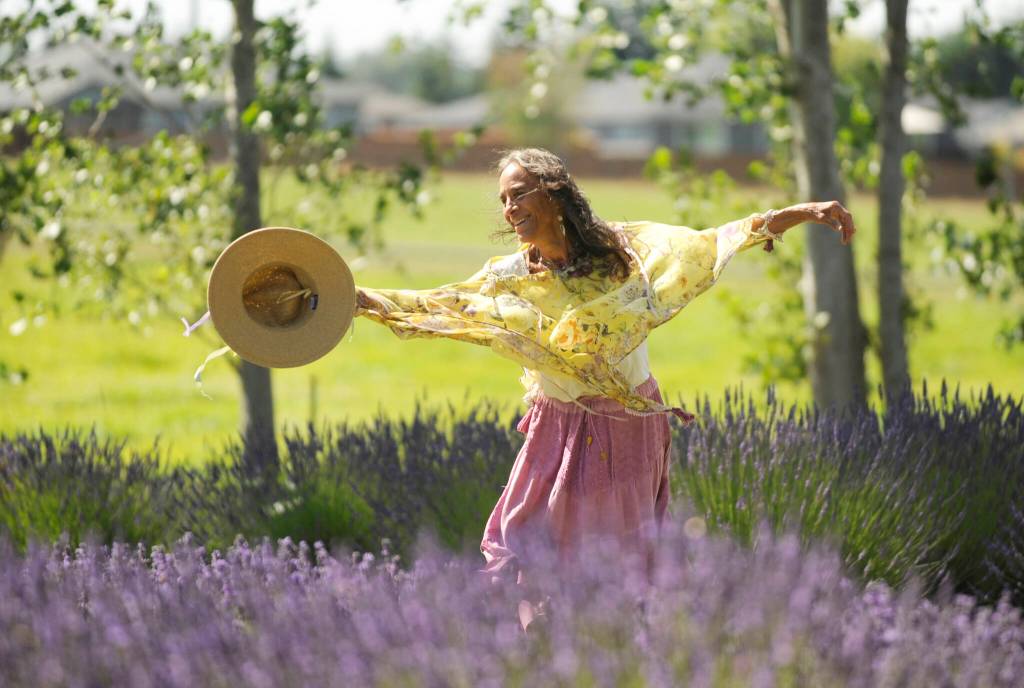 Sequim Gazette photo by Michael Dashiell / Artist KawTee Wolfe dances in the fields as Purple Haze Lavender Farms U-cut field on July 23.