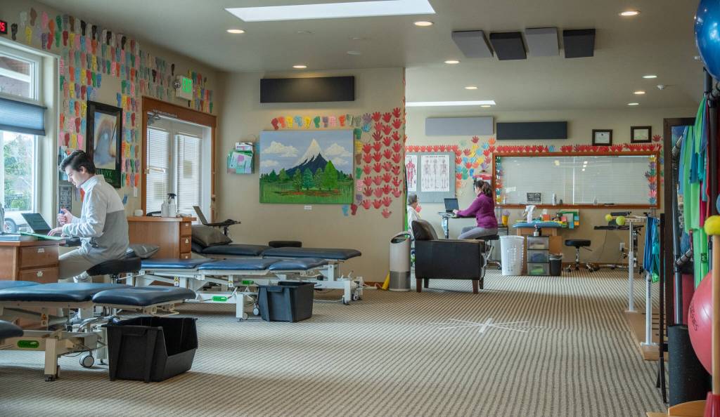 Photo by Emily Matthiessen / The interior of the clinic is structured for sociability, although there is private space for those patients who prefer it. To the left is physical therapist and manager of operations, Daniel Pitz, and in the back is physical therapist and clinical manager Sarah Mattson.
