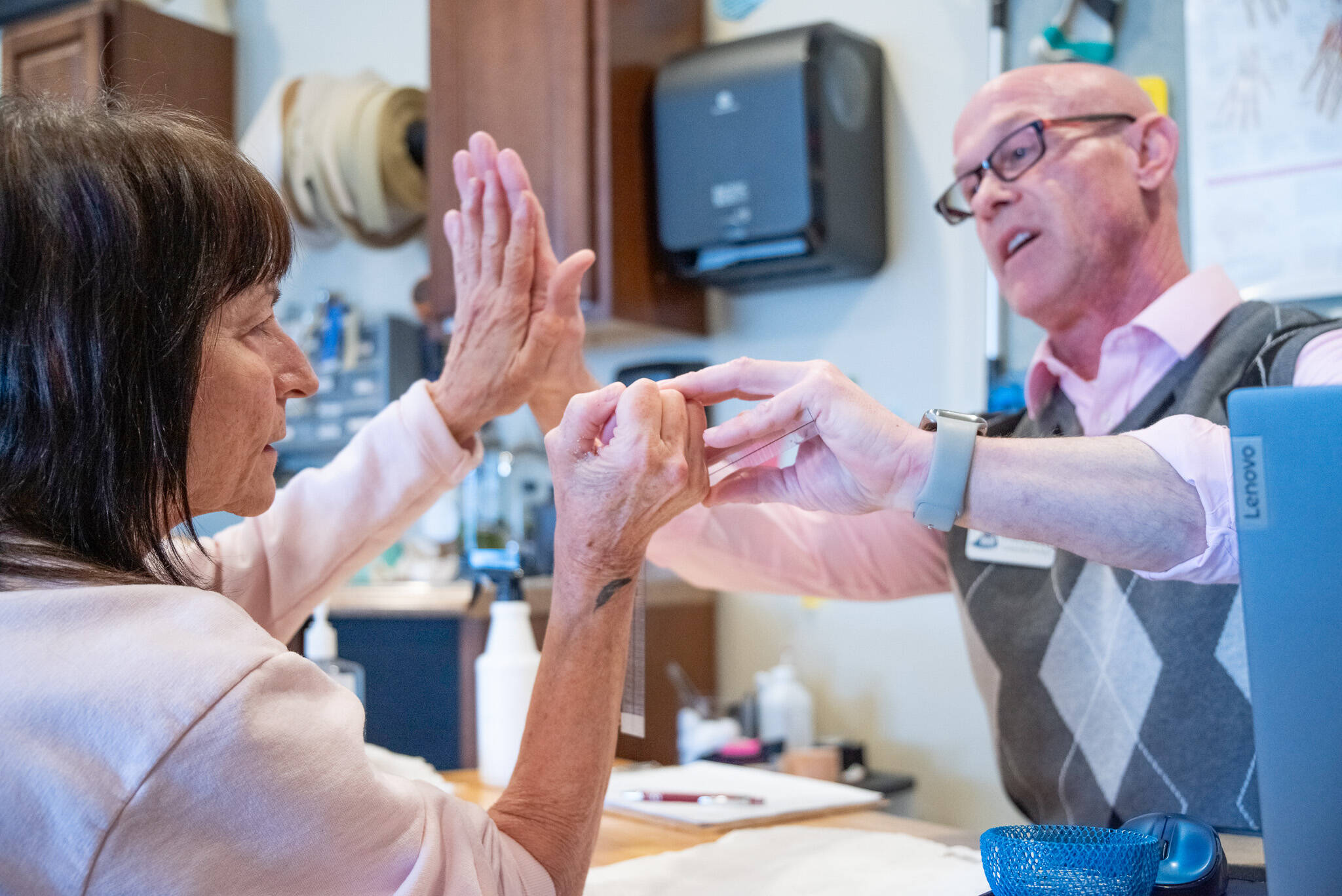 SEQUIM GAZETTE Photos by Emily Matthiessen
Sandy Pufky-Negus and her hand therapist, Aaron Staeben, share a high five as he assesses her wrists range of motion with a goniometer measurement device.