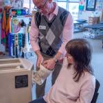 Photo by Emily Matthiessen / Aaron Staeben takes Sandy Pufky-Neguss arm out of a Fluidotherapy dry whirlpool heat treatment during an occupational therapy appointment at Sequims Peak Performance Therapy Center.