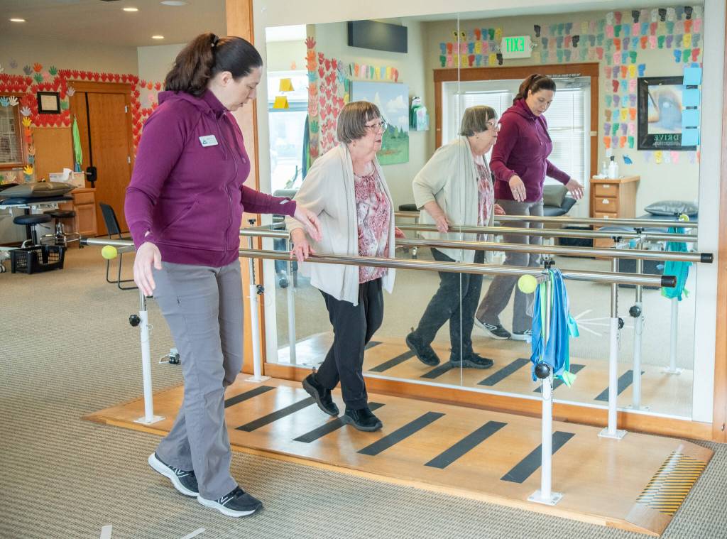 Photo by Emily Matthiessen / Sarah Mattson, physical therapist and clinical manager at Peak Performance Therapy Center in Sequim, guides patient Margo Hewitt through dynamic balance exercises .