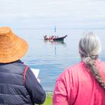 Sequim Gazette photo by Emily Matthiessen / Two ladies watch as a canoe approaches Jamestown Beach for an overnight stop on the intertribal Canoe Journey.