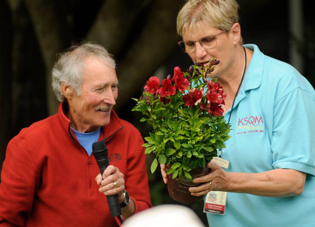 Gardening guru Ciscoe Morris and Susan (KSQM 91.5 FMs Sassy Susan) Sorensen look for the name of a plant theyre about to give away during Morris presentation at the Sequim Prairie Garden Clubs 75th anniversary celebration on July 29 at Pioneer Memorial Park.