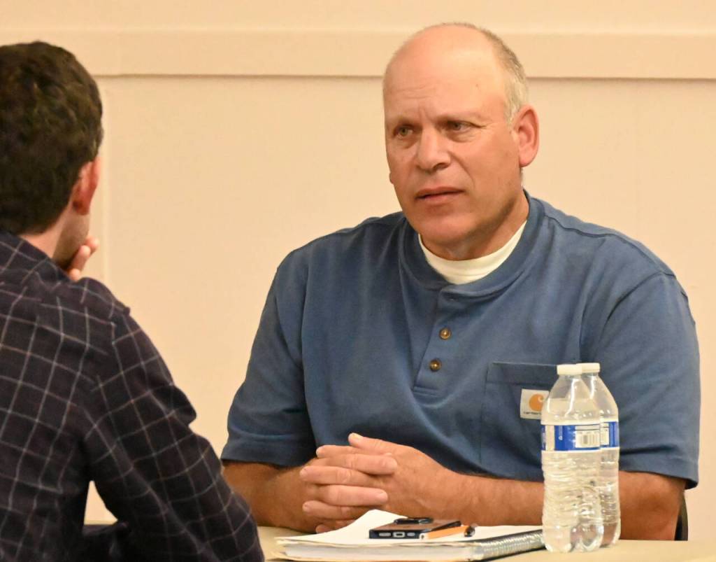 Sequim Gazette photo by Michael Dashiell / Dean Christian, right, speaks with an attendee of The Peoples Forum at the Sequim Prairie Grange on July 13.
