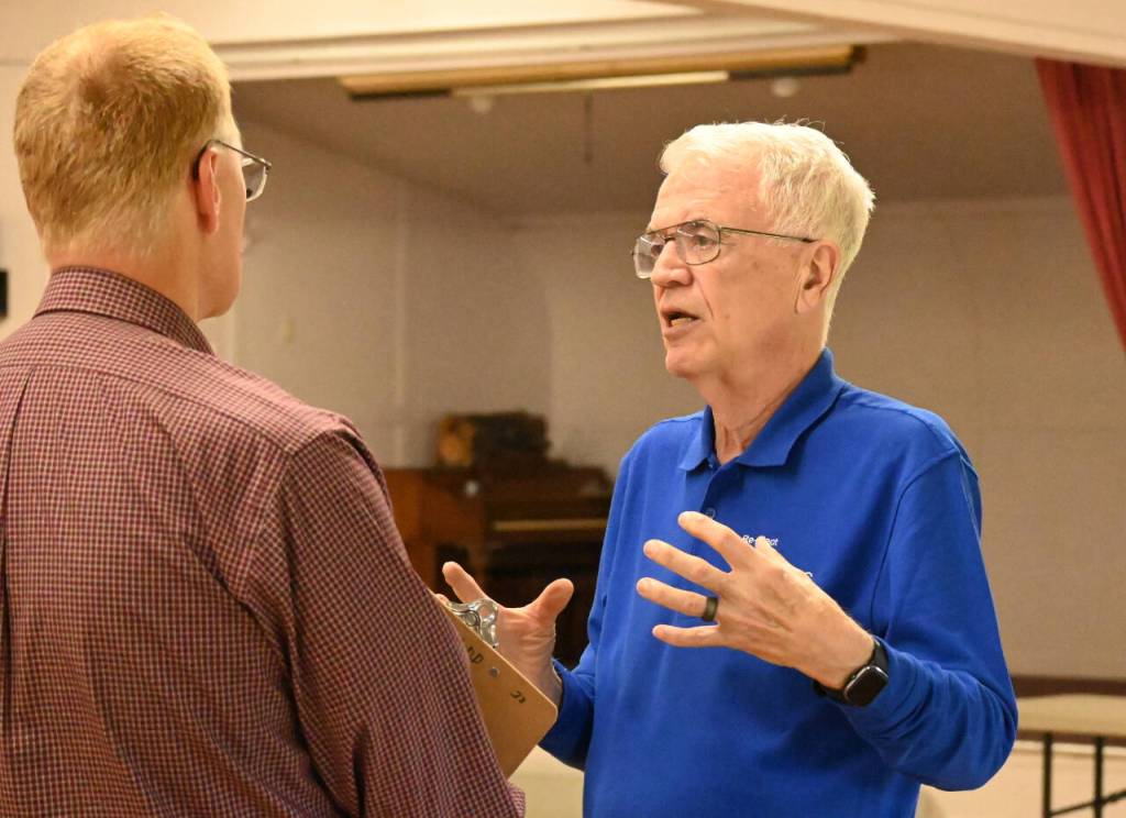 Sequim Gazette photo by Michael Dashiell / Larry Jeffreys, right, speaks with an attendee of The Peoples Forum at the Sequim Prairie Grange on July 13.