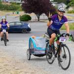 Sequim Gazette Photo by Emily Matthiessen / Stephen Fisher, from the Kenmore area, towing two-year-old Juniper and the pugs Jackie and JoJo, with wife Catherine Creason following, participated in the couples sixth Tour de Lavender this weekend. Creason said that they were married during the event 5 years ago.