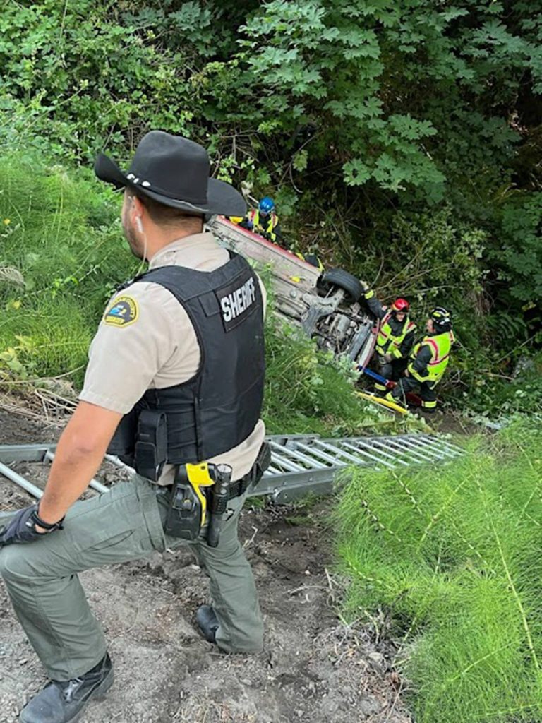 Photo courtesy Clallam County Fire District 3/ First responders prevent a vehicle from sliding further down an embankment after it went off U.S. Highway 101 Monday evening. Its driver, a 61-year-old Sequim woman, died in the crash.