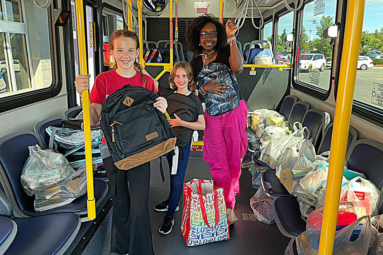 Sequim Gazette photo by Matthew Nash
Members of the Boys & Girls Club, from left, Elliana Holt, 11, Ember Handshaw, 9, and Parker-Rae Jackson, 11, help load school supplies on a Clallam Transit bus during the Stuff the Bus event on Aug. 11 outside the Sequim Walmart. Customers were provided supply lists for students to help with the Back to School Fair on Aug. 26 at the Sequim club.