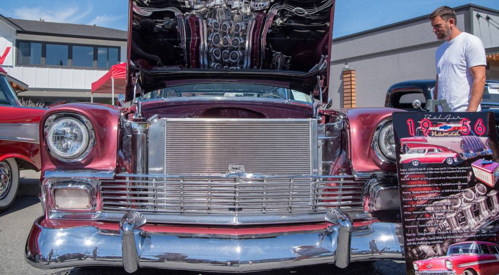 Sequim Gazette photo by Emily Matthiessen / At the Sequim Prairie Nights Car Show, a 1956 Bel Air Nomad attracts passersby with its reflective chrome. The pattern on the underside of the the hood is the reflection of the engine, a Corvette 546 HP.