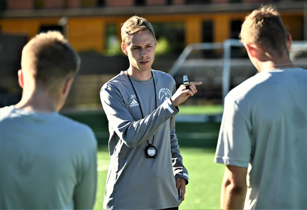 Jake Hughes, head coach of Peninsula Colleges mens soccer program, talks with players at a preseason practice in mid-August.