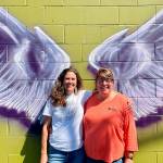Sequim Gazette photo by Matthew Nash/ A new mural by Craig Robinson in downtown Sequim represents a new partnership between Olympic Angels and Habitat for Humanity of Clallam County. Executive director Morgan Hanna with Olympic Angels, on left, said they seek volunteers and mentors to help foster families. Colleen Robinson, chief executive officer for Habitat, said people are welcome to take photos on the wall of Habitats Boutique Store and theyll place a sandwich board sign with information outside, and provide pamphlets about Olympic Angels during business hours.