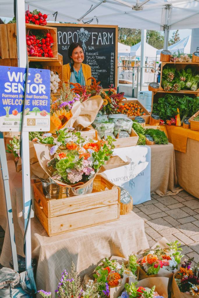 Photo courtesy of Sequim Farmers & Artisans Market/SFAM / Teresa Shiraishi greets visitors at the Tampopo Farms booth at the Sequim Famrers & Artisans Market on Saturdays. Being able to provide accessible, healthy food and interacting with the community are two of her favorite parts of the job.