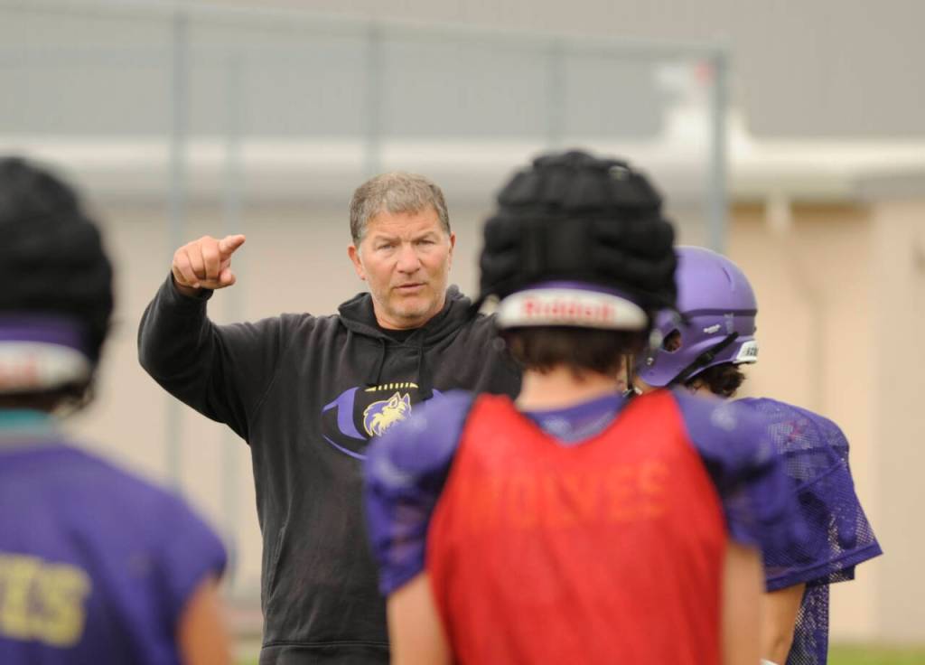 Sequim High head coach Erik Wiker leads his football squad in a preseason practice last week as the Wolves prep for their Sept. 1 season-opener.