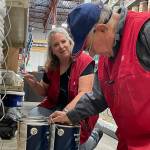 Sequim Gazette photo by Matthew Nash/ Jacqueline Lee, supervisor, and Bob Wasserman, a sales associate, stock paint inside Ace Hardware as they prepare for the Aug. 31 grand opening in the Sequim area.