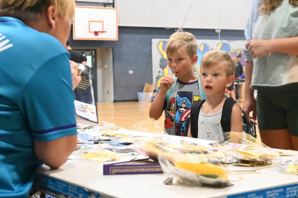Sequim Gazette photo by Michael Dashiell / Lynn Horton, left, chats with Carson Holland, 6, and Wesley Holland, 5, at the 2023 Back to School Fair at the Sequim Boys & Girls Club on Aug. 26. Horton and Sequim Irrigation Festival Royalty handed out packets with bookmarks or earrings with inspirational words to the young fair-goers.
