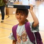 Sequim Gazette photo by Michael Dashiell / Fern Ollerman, 6, finds a unique way to carry a 3-ring binder at the Aug. 26 Back to School Fair. Ollerman is entering first grade.