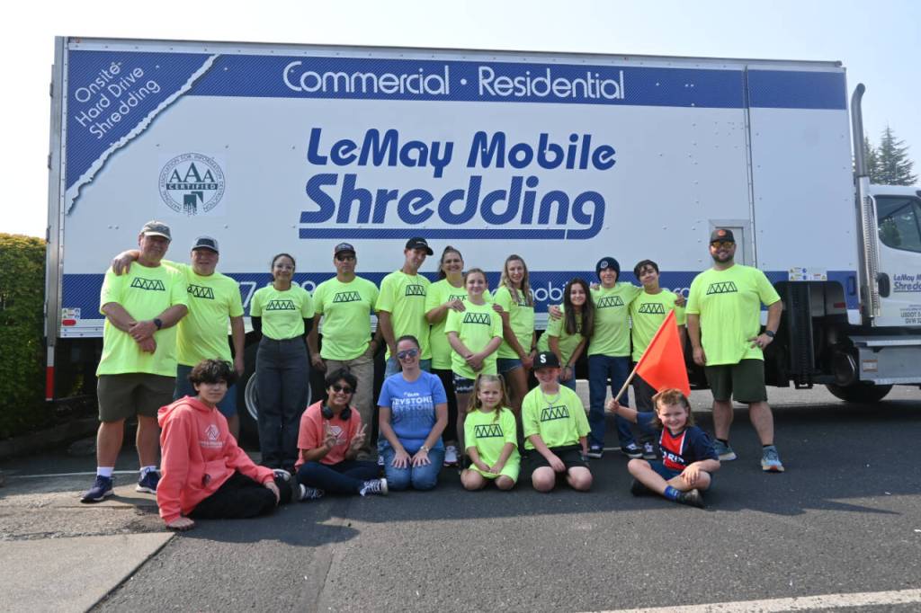 Sequim Gazette photo by Michael Dashiell / Castell Insurance staff and volunteers from the Boys & Girls Club celebrate a record-breaking day at the companys shred event on Aug. 26. The annual fundraiser, which supports the club and its efforts to bolster local students at the Back to School Fair held the same day, topped $7,000 this year, well above the previous record of $5,800.
