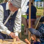 Sequim Gazette file photo by Emily Matthiessen / Bill Huls of the Gilded Thistle, from Renton, plays a stacking game that looks very familiar with three-year-old Aliya Jones at the Northwest Colonial Festival in 2022. It returns Labor Day weekend Sept. 31-Sept. 3 to George Washington Inn.