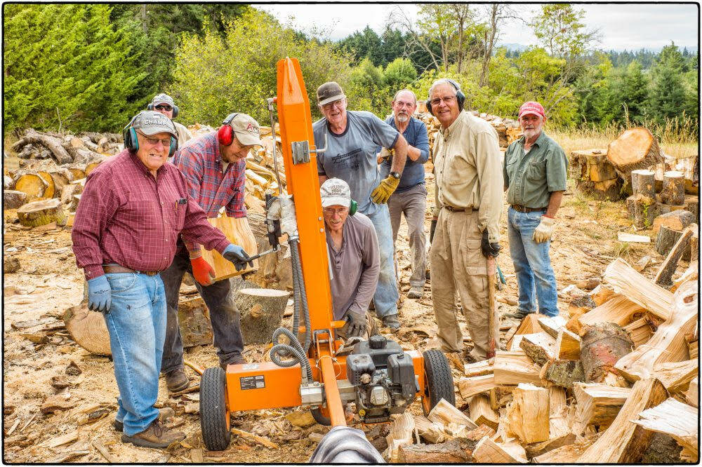 Photo by Bob Lampert / Under the leadership of head woodsman Jack Tatom (center, standing), eight community members spend an early morning on Labor Day (Sept. 4) splitting and chopping wood for donations Path from Poverty, an organization whose goal is to provide drinking water to ladies n Kenya Africa. The group has to date delivered nearly 300 cords of wood in the effort.