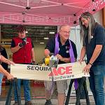 Sequim Gazette photo by Matthew Nash
Store manager Bill McClansburgh saws a sign in half on Aug. 31 to commemorate the grand opening of Sequim Ace Hardware.