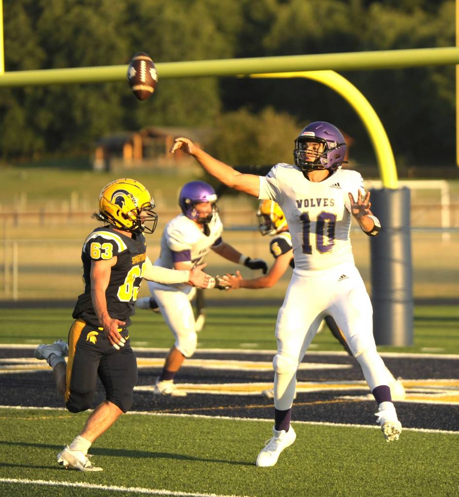 Sequim Gazette photo by Michael Dashiell / Sequim quarterback Lars Wiker looks for an open receiver deep in Wolves territory in the first half of SHS's season-opener at Forks on Sept. 1. Wiker completed the pass to Zeke Schmadeke, and later found younger brother Liam for a pair of touchdowns as Sequim built a 14-0 lead by halftime.