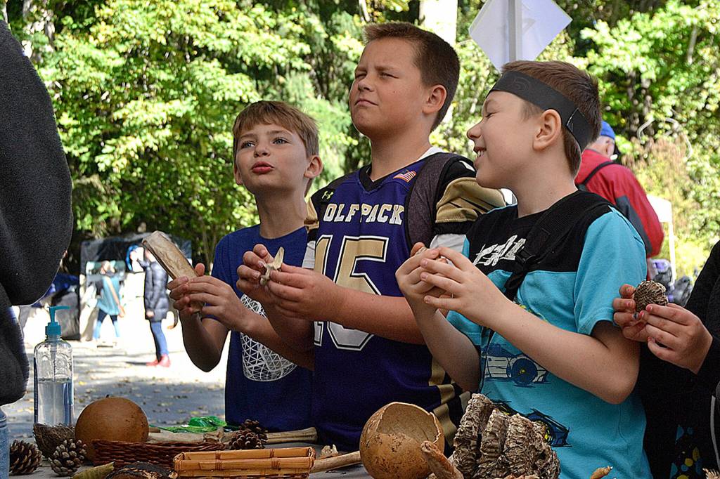 Sequim Gazette file photo by Matthew Nash/ At Olympic Nature Experiences booth during the 2019 Dungeness River Festival, students, from left, Garrett Eldredge, Kaden Miller and Ethan Smith guess what theyre holding.
