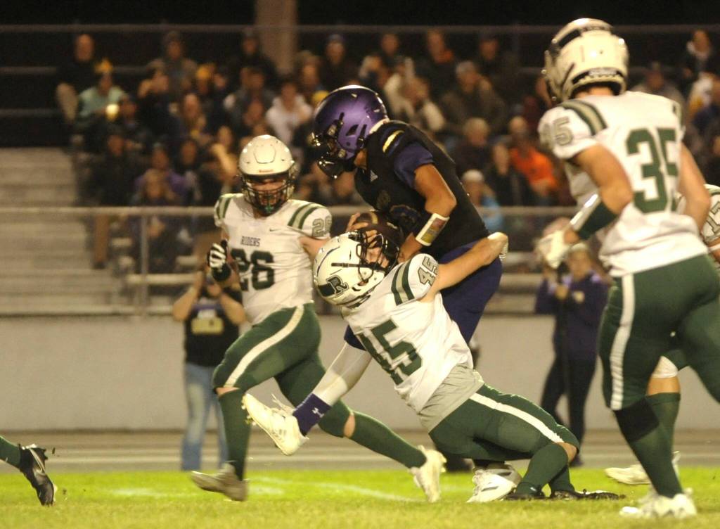 Sequim Gazette photo by Michael Dashiell / A meeting of quarterbacks: Sequims Lars Wiker gains a first down as hes tackled by Port Angeles Parker Nickerson late in the fourth quarter of PAs 37-10 Raindshadow Rumble victory in Sequin=m on Sept. 22.