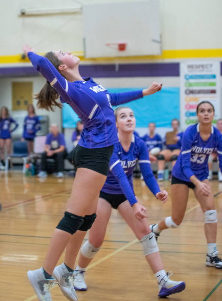 As teammates Sydney Clark, center, and Arianna Stovall, right, look on, Sequims Rose Gibson goes up for a hit in the Wolves Sept. 21 match-up with North Kitsap.