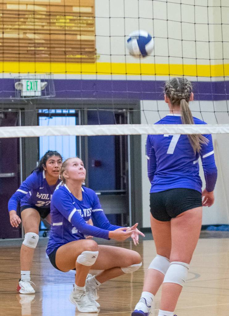 Sequim Gazette photo by Emily Matthiessen / As teammates assi Montero, left, and Sydney Clark, right, look on Sequims Jolene Vaara digs a ball and passes to a teammate in the Wolves Sept. 21 home match against North Kitsap.