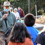 Volunteer Bob Boekelheide greets students during the Dungeness River Festival. He led students on a hunt for animals in a large mural by late-artist Tim Quinn.