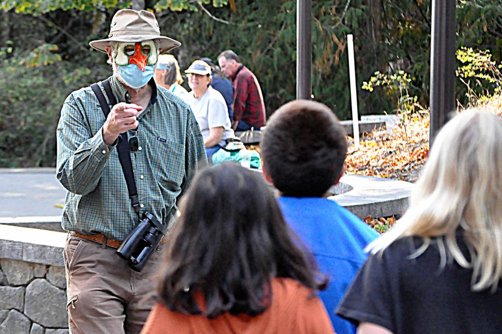Volunteer Bob Boekelheide greets students during the Dungeness River Festival. He led students on a hunt for animals in a large mural by late-artist Tim Quinn.